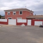 Portail aluminium de couleur blanche sur muret rouge avec maison