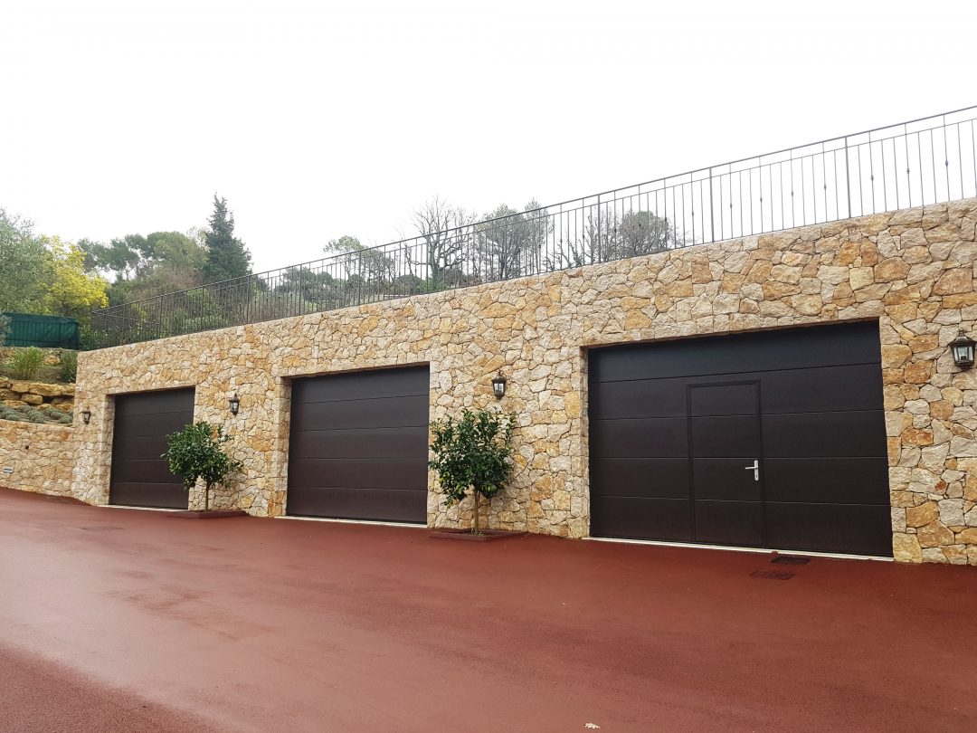 portes de garages sur mur en pierre