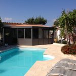 véranda noire avec terrasse et piscine