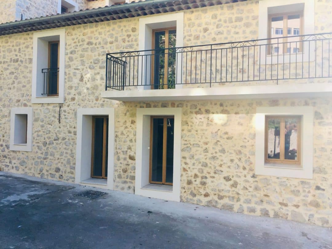 maison en pierre moderne avec fenêtres rectangulaires en PVC