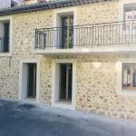 maison en pierre moderne avec fenêtres rectangulaires en PVC